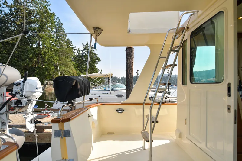 Island Harmony Yacht Photos Pics 2012 North Pacific NP 38 Sedan yacht deck with ladder, docked in a scenic marina.