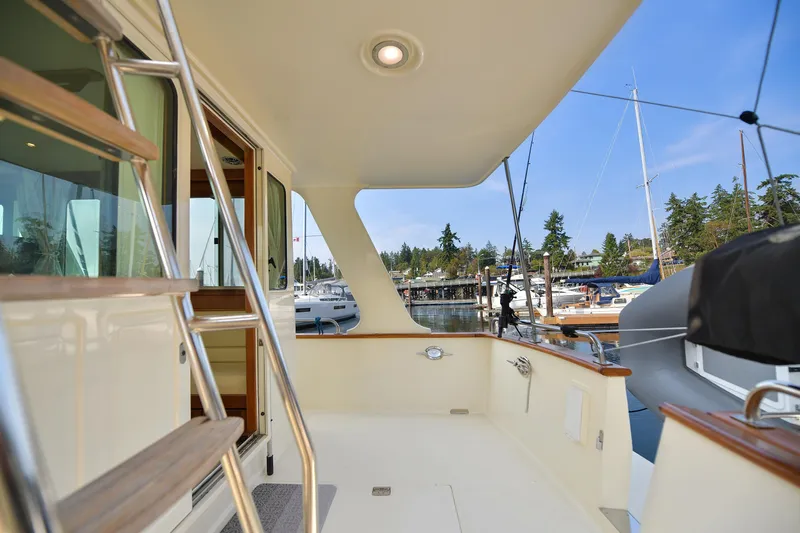 Island Harmony Yacht Photos Pics 2012 North Pacific NP 38 Sedan yacht deck with marina view, featuring ladder and seating area.