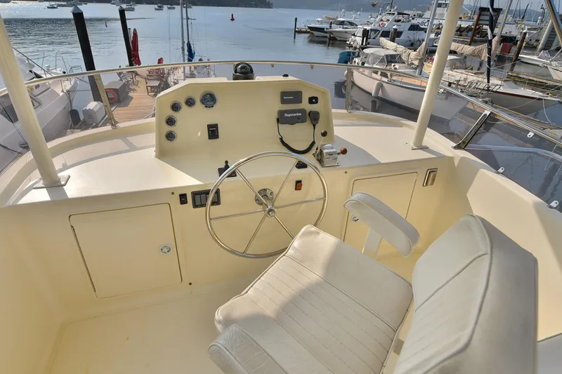 Island Harmony Yacht Photos Pics Helm of 2012 North Pacific NP 38 Sedan yacht at marina, featuring steering wheel and controls.