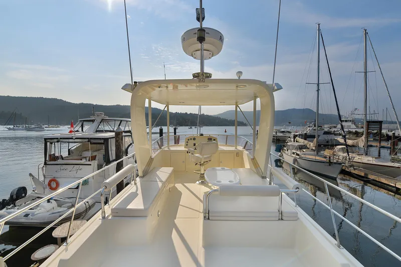 Island Harmony Yacht Photos Pics 2012 North Pacific NP 38 Sedan yacht docked at a marina, surrounded by sailboats.