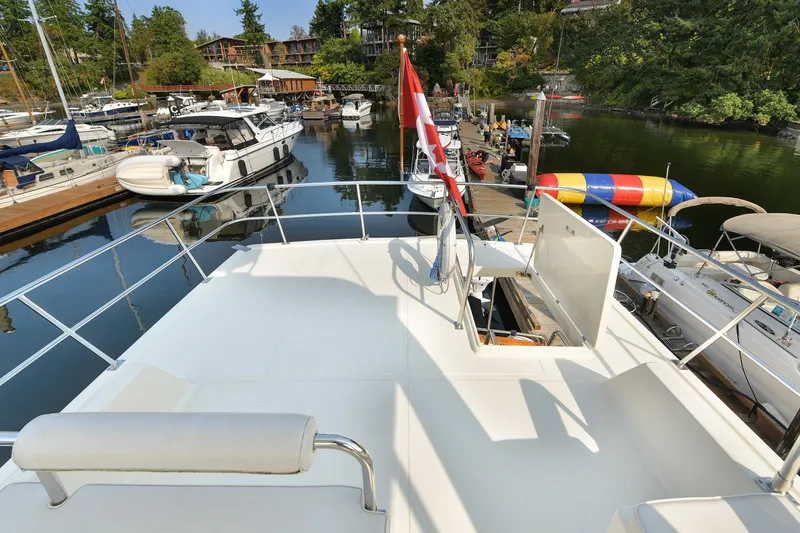 Island Harmony Yacht Photos Pics 2012 North Pacific NP 38 Sedan yacht docked at a scenic marina with surrounding boats.