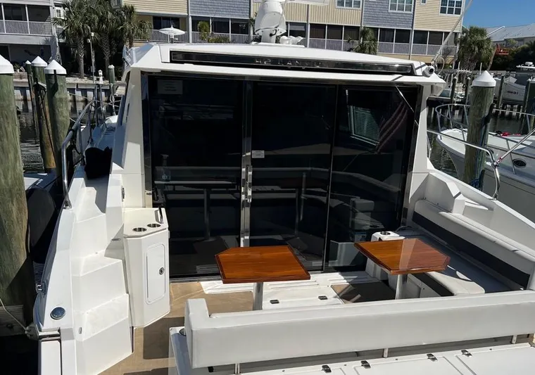  Yacht Photos Pics 2018 Cruisers Yachts 42 Cantius with outdoor seating and tables at a marina.