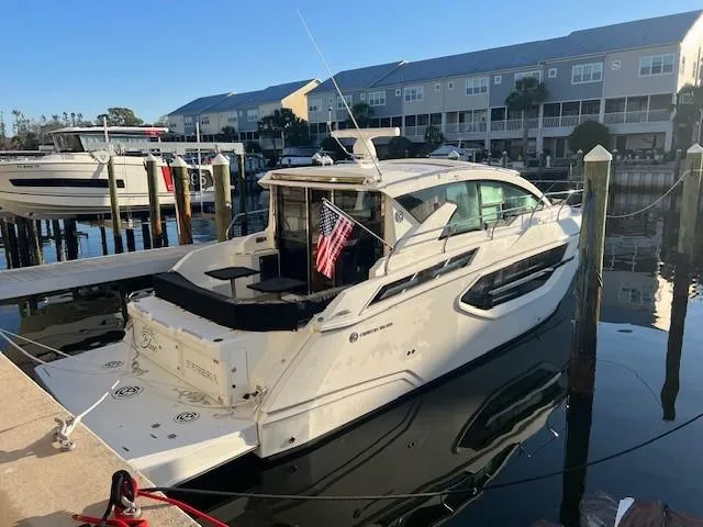  Yacht Photos Pics 2018 Cruisers Yachts 42 Cantius docked at marina, featuring sleek design and American flag.