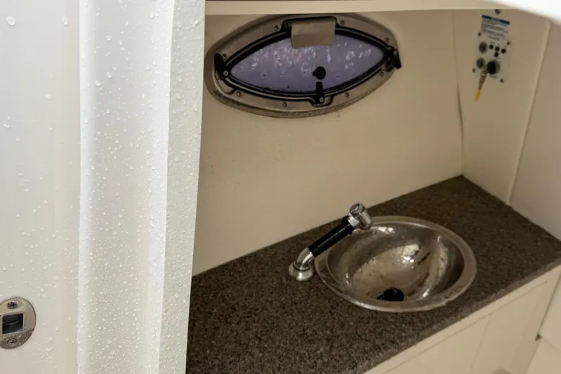  Yacht Photos Pics 2024 Robalo R317 Dual Console boat interior with sink and porthole window.