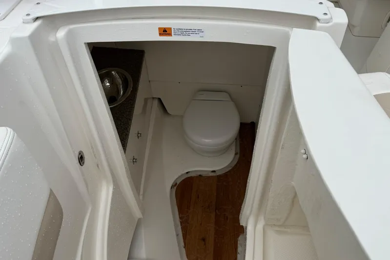  Yacht Photos Pics 2024 Robalo R317 Dual Console boat interior bathroom with toilet and sink.