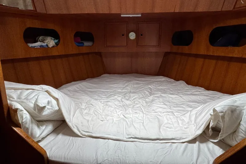 Giksea Yacht Photos Pics Cozy cabin interior of 1989 Franchini Atlantide 42 yacht with wooden finish and bedding.