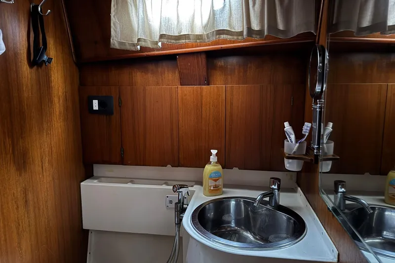 Giksea Yacht Photos Pics Bathroom interior of 1989 Franchini Atlantide 42 yacht with sink and wooden paneling.