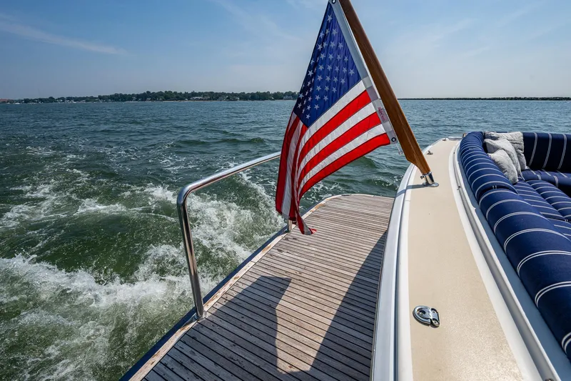 Duet Yacht Photos Pics Grand Banks 44 Eastbay SX 2017 yacht with American flag on deck, cruising on open water.