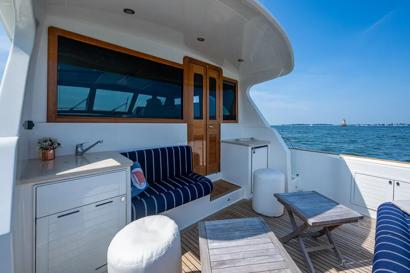 Duet Yacht Photos Pics 2017 Grand Banks 44 Eastbay SX yacht deck with seating, table, and ocean view.