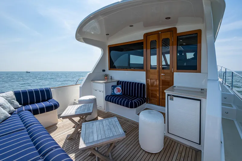 Duet Yacht Photos Pics Luxurious 2017 Grand Banks 44 Eastbay SX yacht deck with striped seating and ocean view.