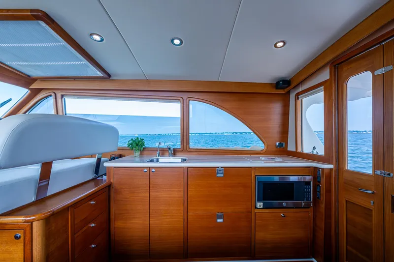 Duet Yacht Photos Pics Luxurious 2017 Grand Banks 44 Eastbay SX yacht interior with wooden cabinetry and ocean view.