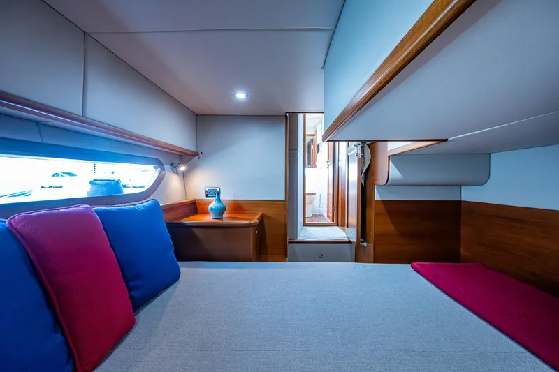 Duet Yacht Photos Pics Luxurious cabin interior of 2017 Grand Banks 44 Eastbay SX yacht, featuring cozy bedding and elegant wood finishes.