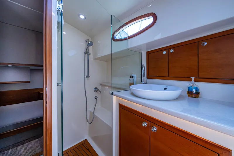Duet Yacht Photos Pics Luxurious bathroom in 2017 Grand Banks 44 Eastbay SX yacht with modern fixtures and wooden cabinetry.