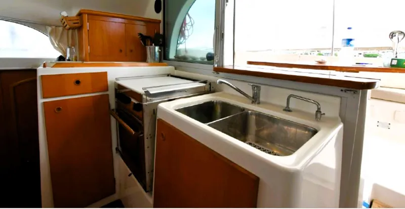 Tortuga Yacht Photos Pics Interior of 2001 Lagoon 380 catamaran kitchen with wooden cabinets and dual sinks.