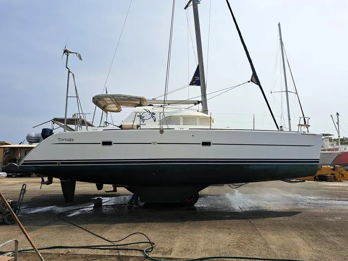 Tortuga Yacht Photos Pics 2001 Lagoon 380 catamaran on dry dock, side view, with sails and equipment visible.