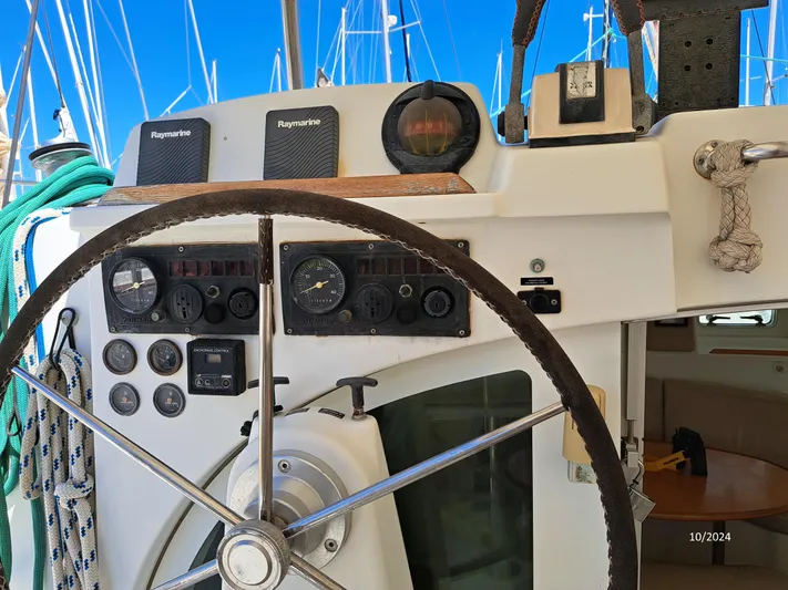 Tortuga Yacht Photos Pics Steering wheel and controls of a 2001 Lagoon 380 catamaran, docked in a marina.