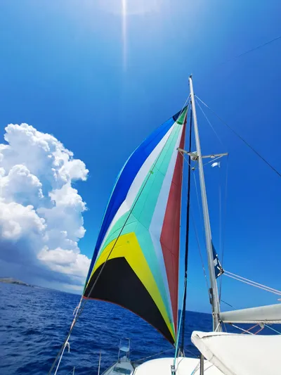 Tortuga Yacht Photos Pics Colorful sail on Lagoon 380 catamaran, 2001 model, against clear blue sky and ocean.
