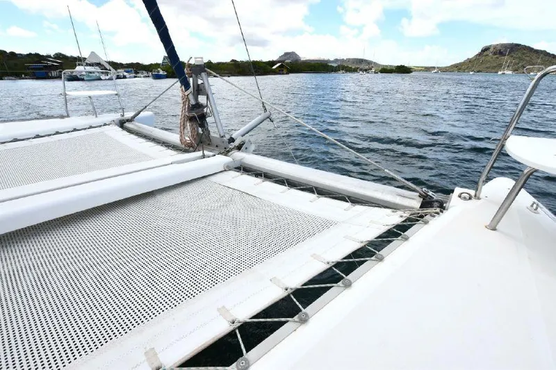 Tortuga Yacht Photos Pics Catamaran Lagoon 380, 2001 model, sailing on calm waters with scenic background.