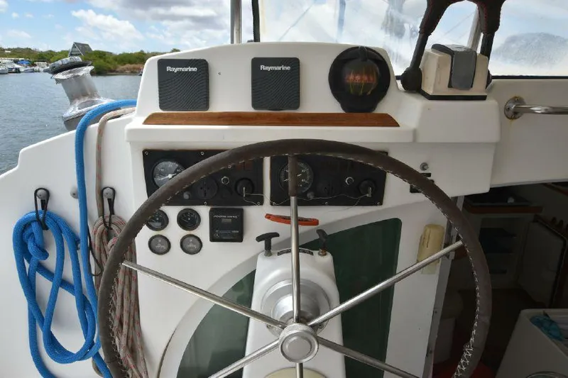 Tortuga Yacht Photos Pics Steering wheel and controls of a 2001 Lagoon 380 catamaran, featuring Raymarine equipment.