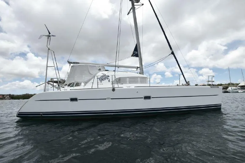 Tortuga Yacht Photos Pics 2001 Lagoon 380 catamaran sailing on calm waters under a cloudy sky.