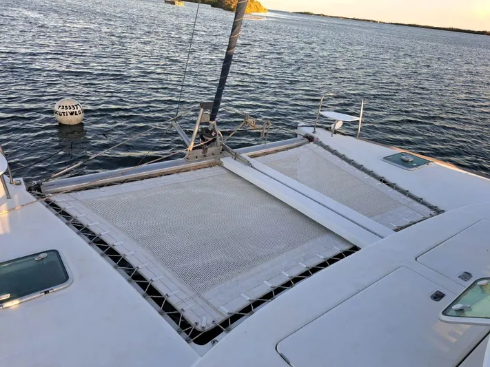 Tortuga Yacht Photos Pics Lagoon 380 catamaran, 2001 model, anchored on calm water with visible netting and deck.