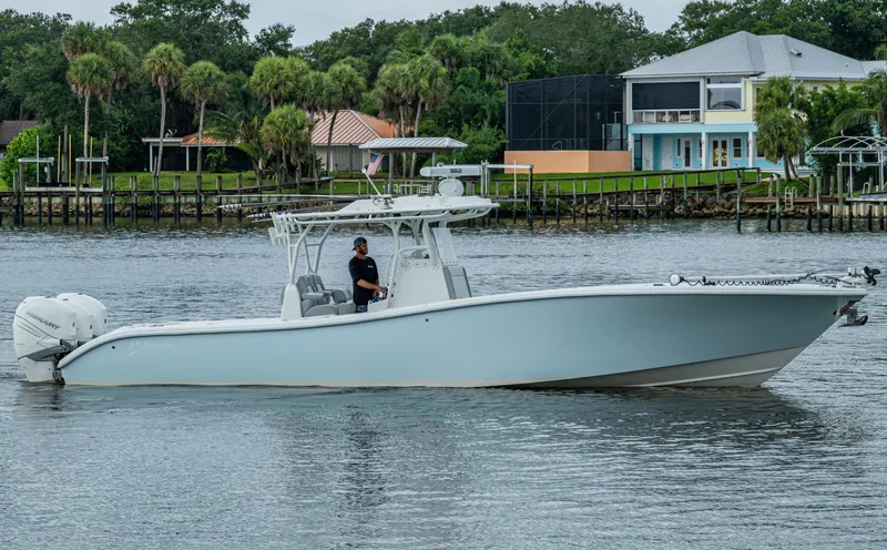  Yacht Photos Pics 2018 Yellowfin 36 Offshore boat on calm water near waterfront homes.