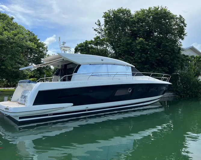The Best Day Ever Yacht Photos Pics 2013 Prestige 500 S yacht docked on calm water, surrounded by lush greenery.
