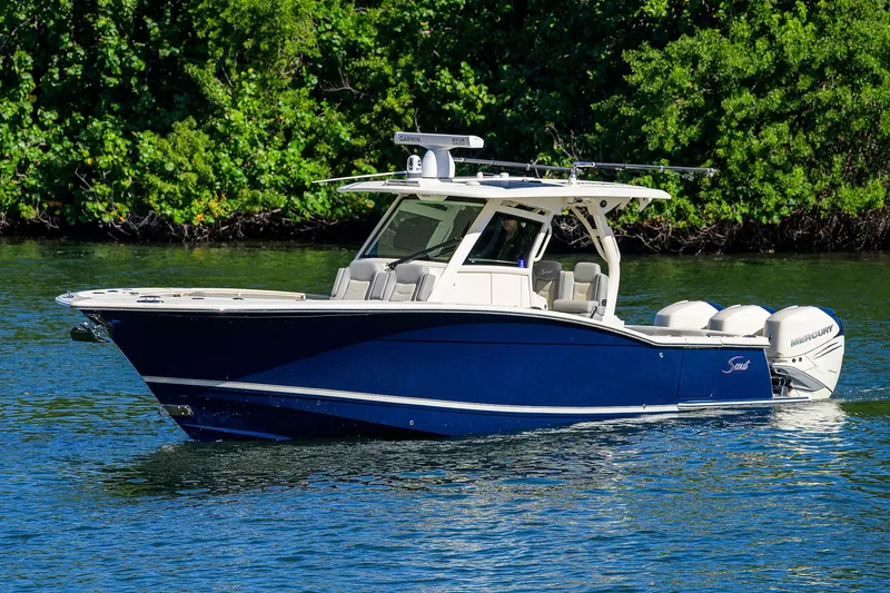 W/seakeeper Yacht Photos Pics 2023 Scout 355 LXF boat on water, surrounded by lush greenery.