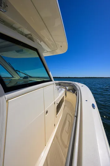 W/seakeeper Yacht Photos Pics 2023 Scout 355 LXF boat on water, showcasing sleek design and clear blue sky.