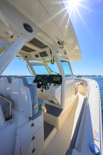 W/seakeeper Yacht Photos Pics 2023 Scout 355 LXF boat interior with helm, seats, and sunny sky.