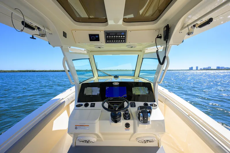W/seakeeper Yacht Photos Pics 2023 Scout 355 LXF boat helm with modern controls, navigating open water.
