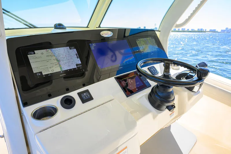 W/seakeeper Yacht Photos Pics 2023 Scout 355 LXF boat helm with advanced navigation displays and steering wheel.