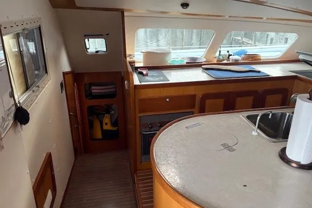  Yacht Photos Pics Interior of 2004 Soubise Plaisance Freydis 46 catamaran with kitchen and wooden cabinetry.