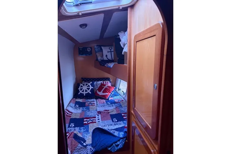  Yacht Photos Pics Cozy cabin interior of 2004 Soubise Plaisance Freydis 46 with nautical-themed bedding.