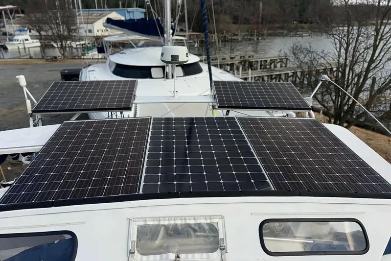  Yacht Photos Pics Soubise Plaisance Freydis 46 catamaran with solar panels, docked near a serene waterfront.