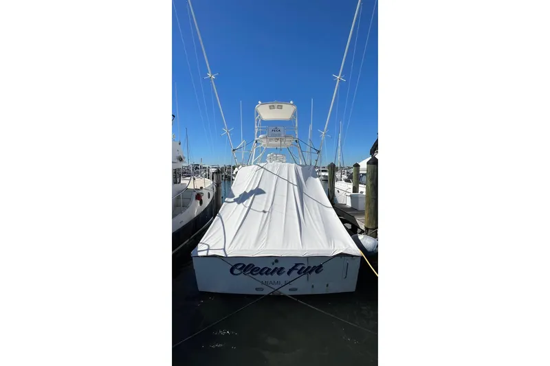 Clean Fun Yacht Photos Pics 2005 Rampage 38 Express boat docked, covered, with clear blue sky background.