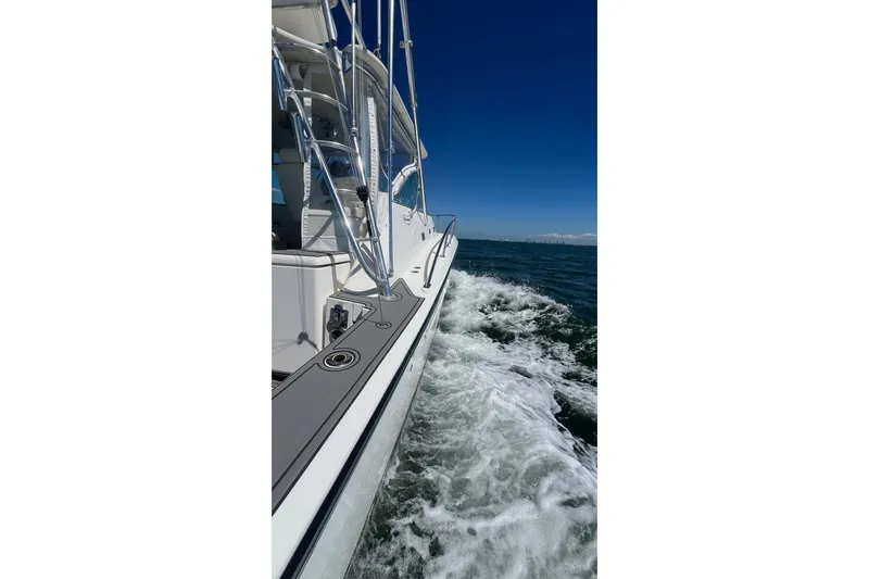 Clean Fun Yacht Photos Pics 2005 Rampage 38 Express cruising on open water under clear blue skies.