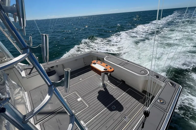 Clean Fun Yacht Photos Pics 2005 Rampage 38 Express boat cruising on open sea, featuring spacious deck and fishing equipment.