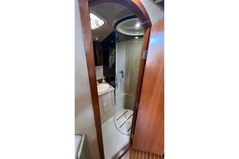 Clean Fun Yacht Photos Pics 2005 Rampage 38 Express yacht bathroom with shower, sink, and wooden door.