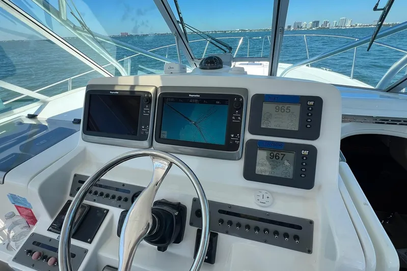 Clean Fun Yacht Photos Pics Helm of 2005 Rampage 38 Express boat with navigation screens and steering wheel.