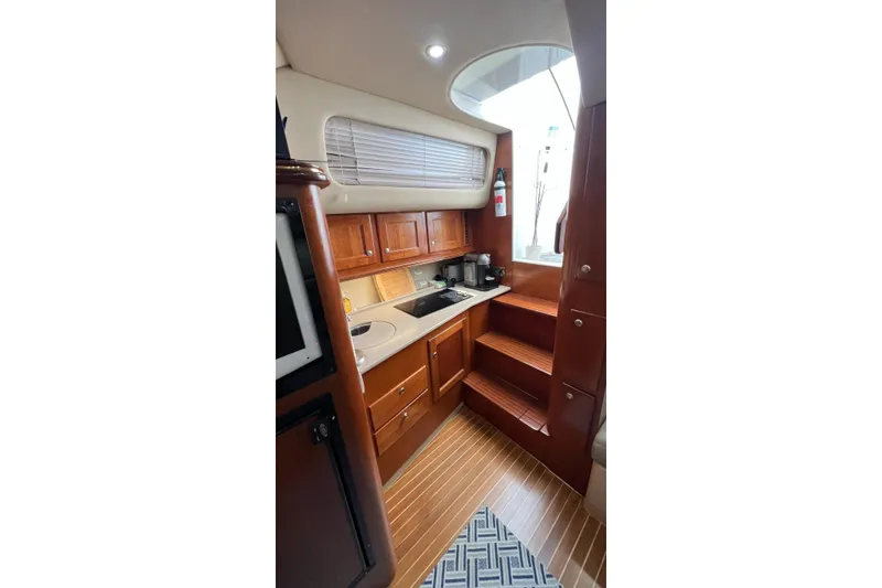 Clean Fun Yacht Photos Pics 2005 Rampage 38 Express yacht interior with wooden cabinetry and compact kitchen area.