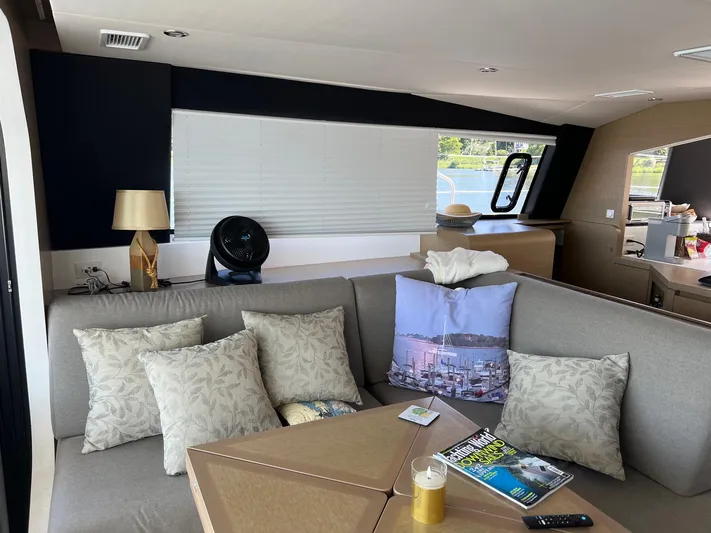 Tri It Yacht Photos Pics Luxurious NEEL 51 yacht interior with cozy seating, decorative pillows, and a modern table setup.