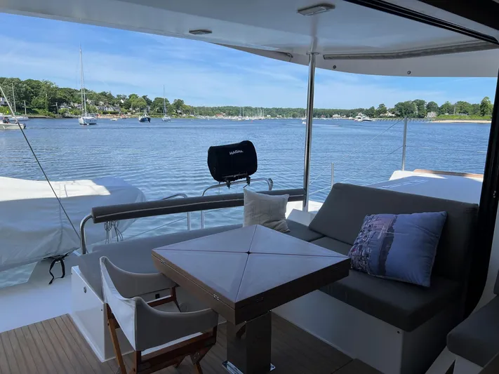 Tri It Yacht Photos Pics Spacious deck of 2018 NEEL 51 trimaran with seating, overlooking serene waters and distant shoreline.