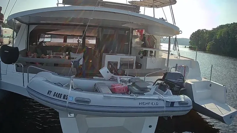 Tri It Yacht Photos Pics NEEL 51 trimaran with inflatable boat, docked on a serene lake, 2018 model.