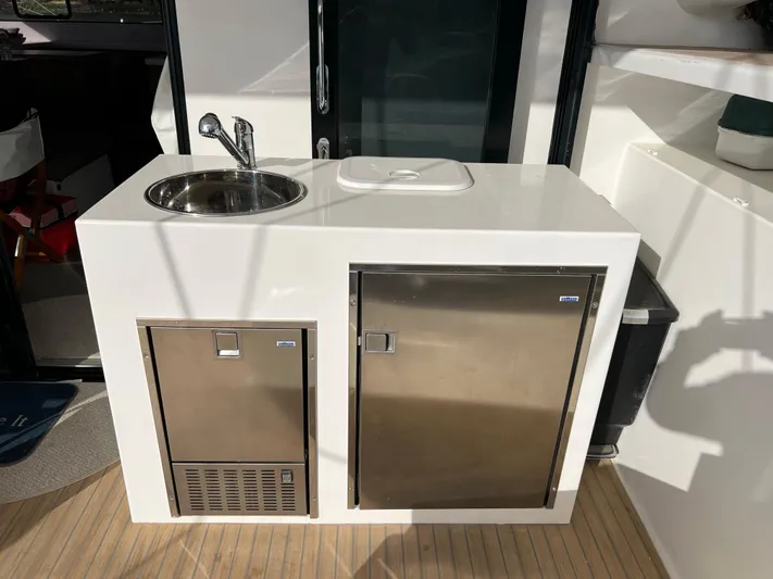 Tri It Yacht Photos Pics Outdoor kitchenette on NEEL 51 trimaran, featuring sink and stainless steel storage, 2018 model.