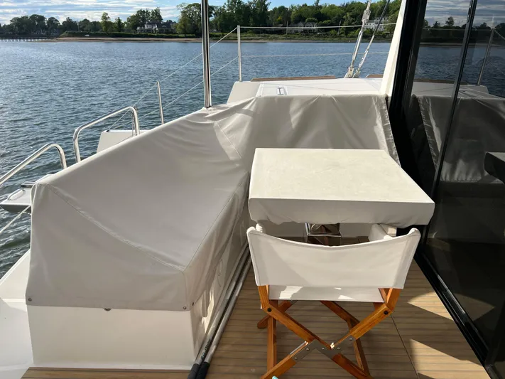 Tri It Yacht Photos Pics Deck of 2018 NEEL 51 trimaran with seating and table, overlooking calm waters.