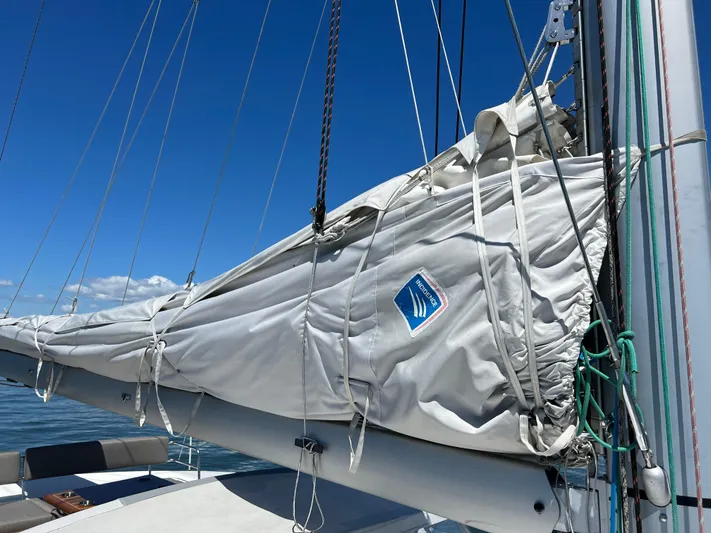 Tri It Yacht Photos Pics Sailboat mast and sail cover on a 2018 NEEL 51 trimaran under clear blue sky.