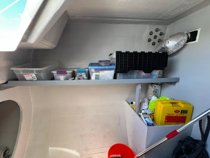 Tri It Yacht Photos Pics Storage area inside a 2018 NEEL 51, featuring organized shelves and cleaning supplies.