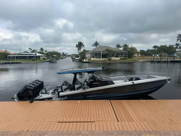  Yacht Photos Pics 2025 Nor-Tech 400SS boat docked by a scenic waterfront under cloudy skies.