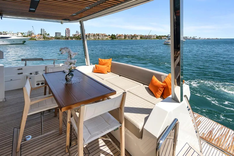 Smile Yacht Photos Pics Astondoa 66 Flybridge 2023 yacht deck with seating, table, and ocean view.